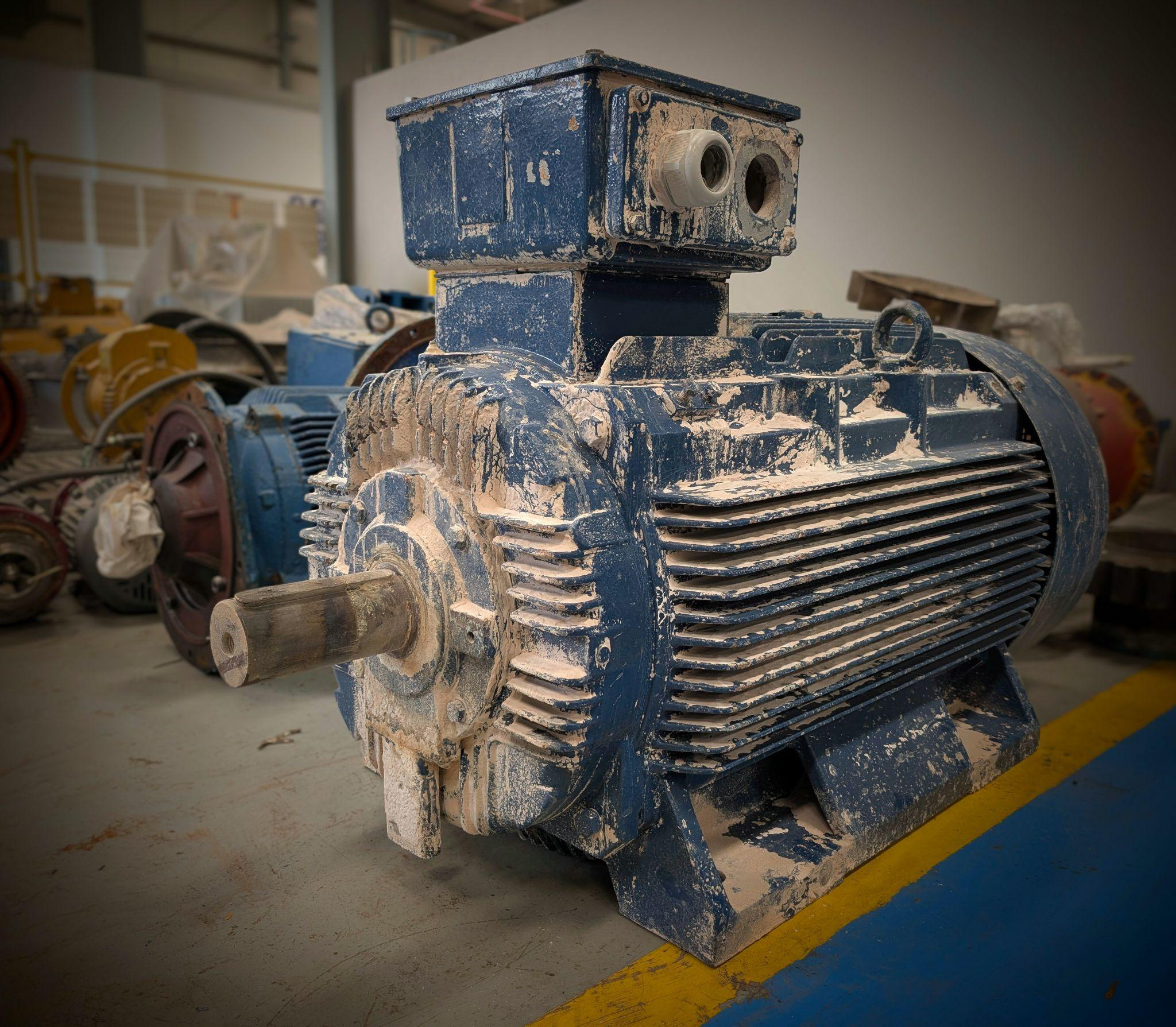 Dust-covered industrial electric motor at a cement plant ready for overhauling